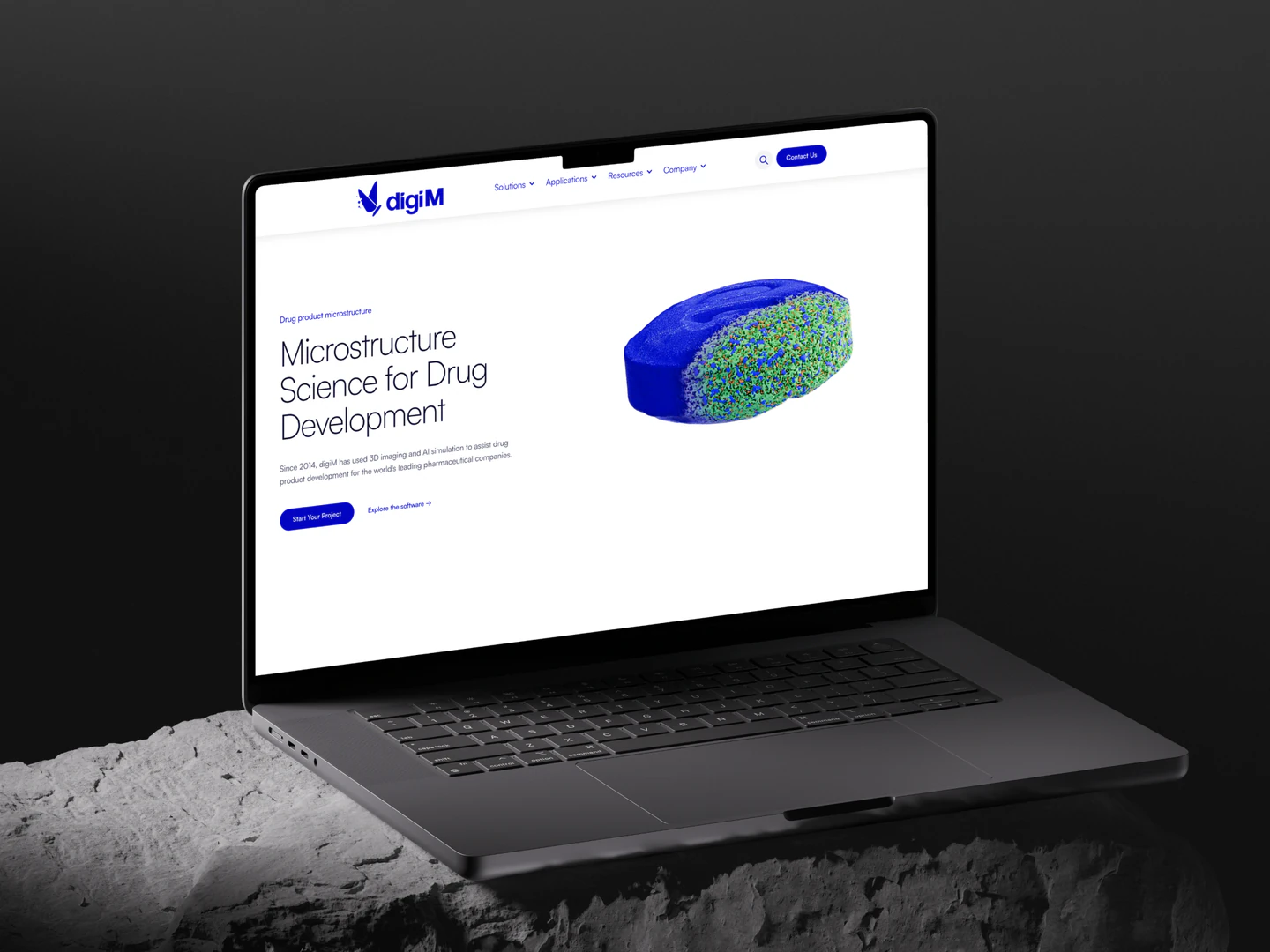 digiM homepage on a laptop resting on a rock