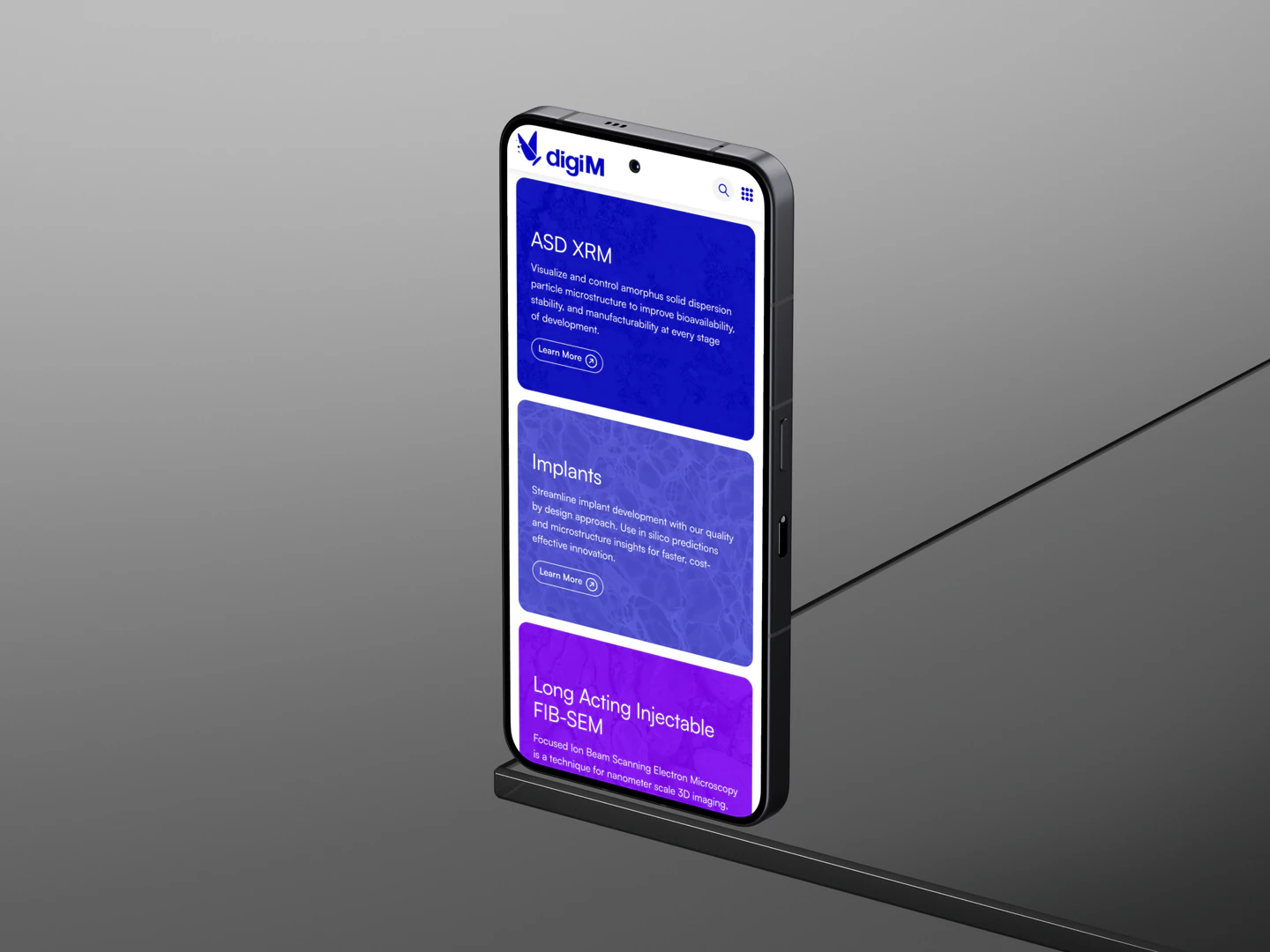 digiM mobile applications page on a phone standing on a narrow ledge