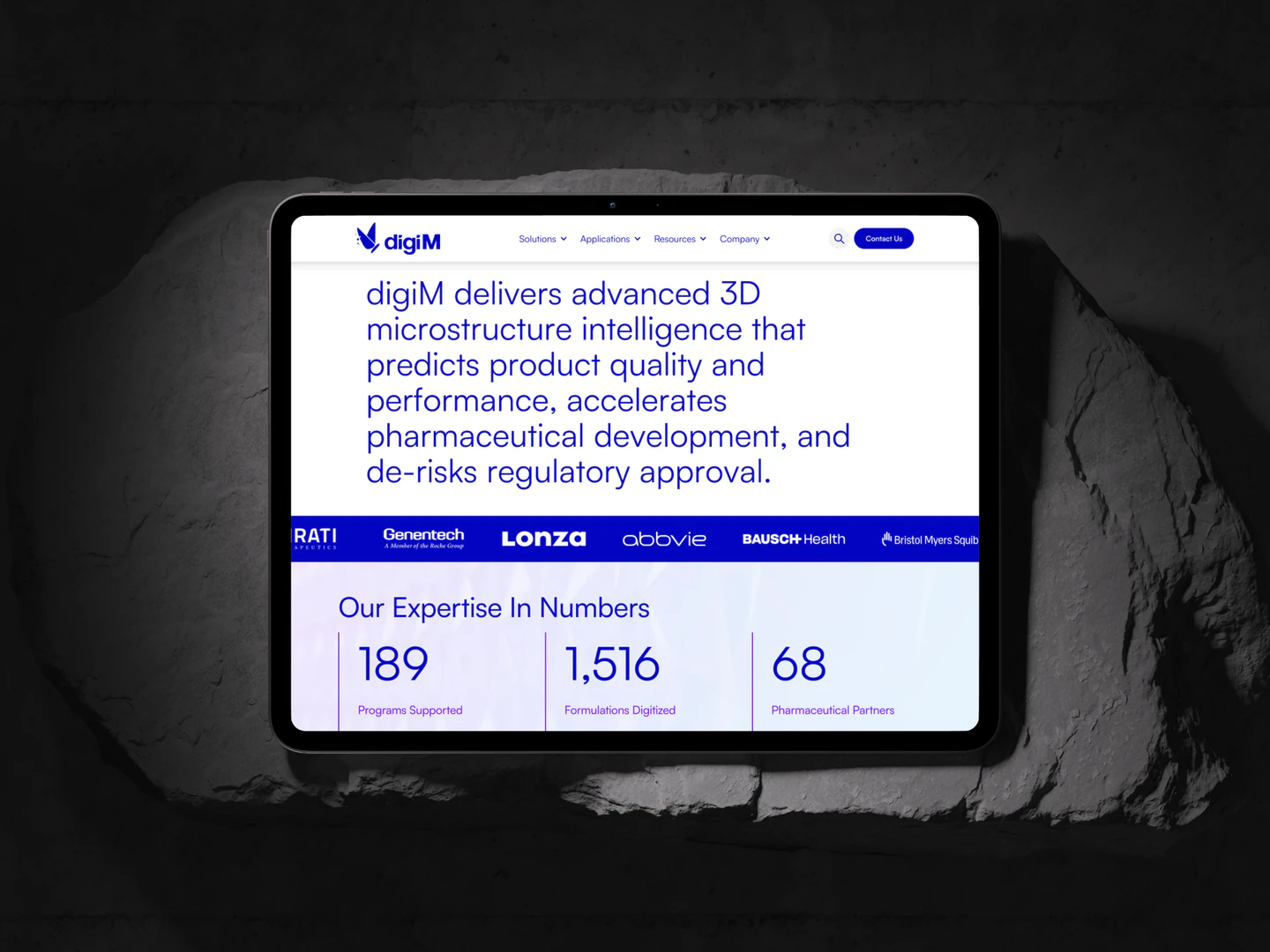 digiM company overview and expertise on a tablet resting on a rock