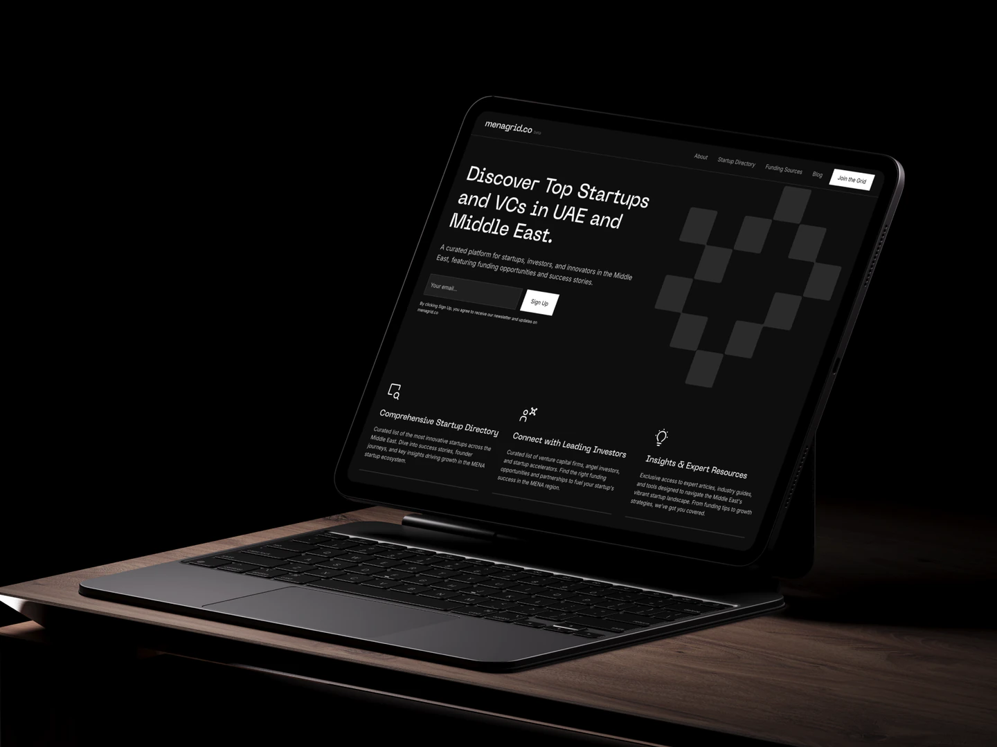 Menagrid homepage displayed on a tablet with a keyboard on a desk