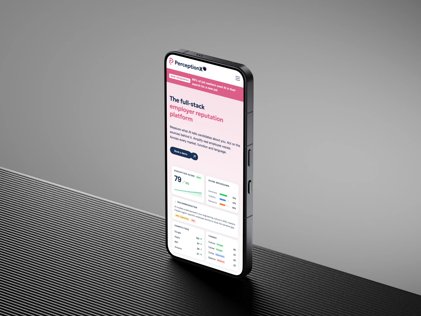 PerceptionX mobile homepage on a phone standing on a textured surface