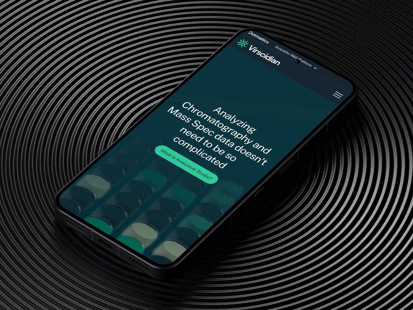 Virscidian analytical research homepage displayed on a phone on a circular textured surface
